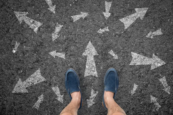 Man standing on road with many direction arrow choices or move — Stock Photo, Image