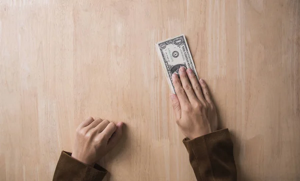 Businessman hand giving dollar money on wooden table. — Stock Photo, Image