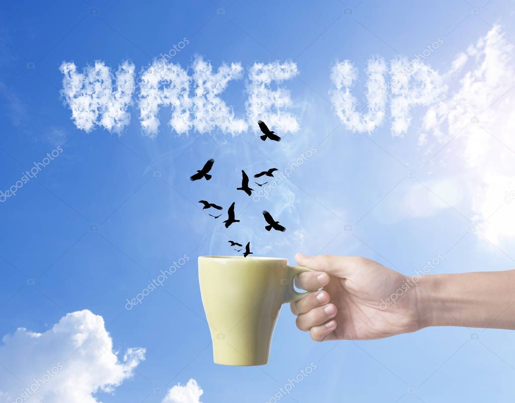 hand holding green coffee cup with bird and wake up text on sky 