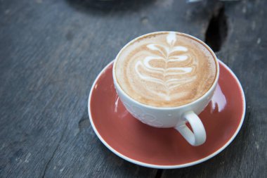 sıcak latte sanat üzerinde ahşap masa kahve fincan yukarıda.