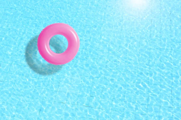 Anello piscina rosa galleggiante in acqua blu . — Foto Stock