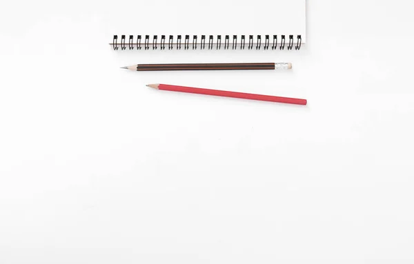 Feletti felső Kilátás jegyzetfüzet ceruza fehér asztali háttér. — Stock Fotó