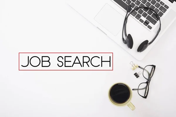 Bureau met zakboekje computer en formulering van Job search — Stockfoto