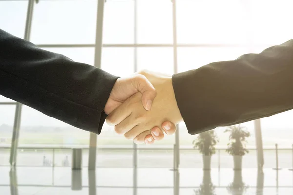 Business people handshake in office background.