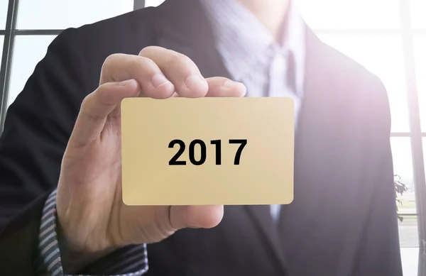 Hand hält eine Visitenkarte mit der Botschaft "Frohes neues Jahr 2017" — Stockfoto