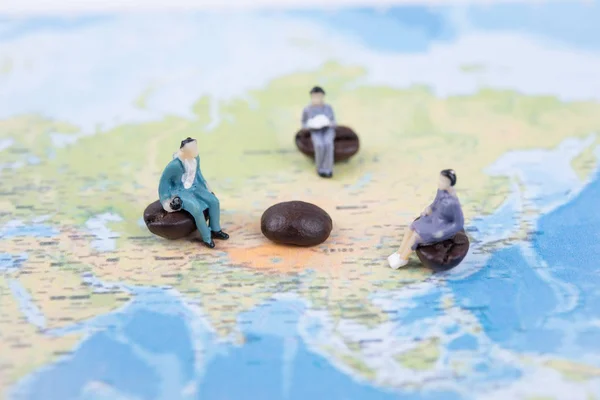 Las personas en miniatura se sientan en el mapa mundial. negocios internacionales comunicarse — Foto de Stock