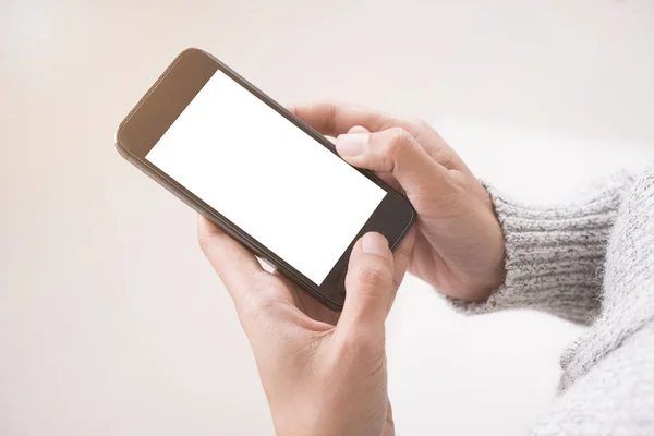 Usando el teléfono inteligente que muestra la pantalla blanca en blanco en la mano de mujer . — Foto de Stock