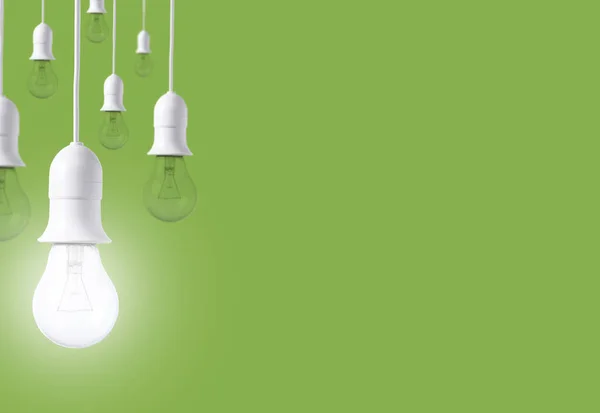 Diferença lâmpada no fundo verde. conceito de novas ideias — Fotografia de Stock