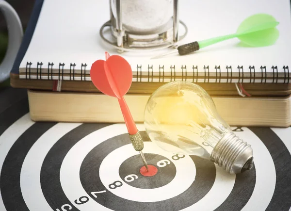 Lightbulb on dartboard with arrow. concept goal for new ideas — Stock Photo, Image