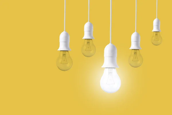 Lampadina differenza su sfondo giallo. concetto di nuove idee — Foto Stock