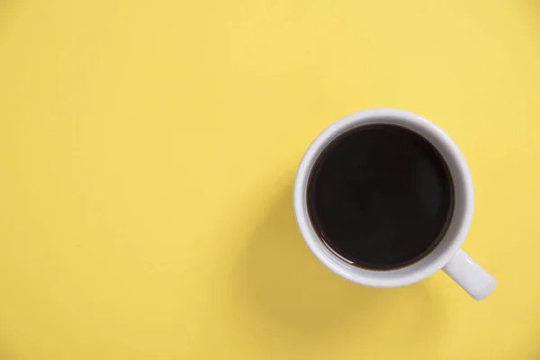 Vista superior plano de la taza de café sobre fondo amarillo. espacio de copia — Foto de Stock