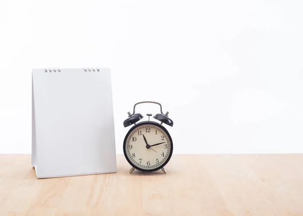 Порожній планувальник календаря з годинником і дерев'яним столом на білому — стокове фото
