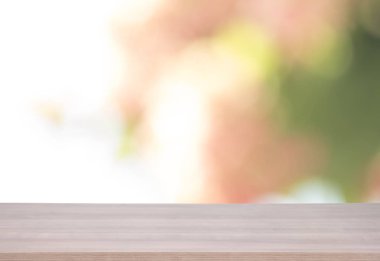 Ahşap masa üstü ürün için yeşil ve pembe bokeh arka plan üzerinde 