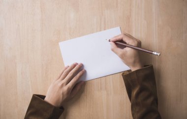 iş el ahşap masa ofis bir not kağıdına yazmak. Üstten Görünüm 