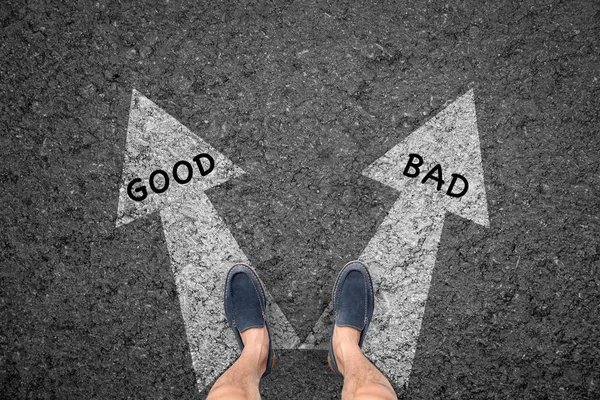 man standing on road with direction arrow choices Good and Bad