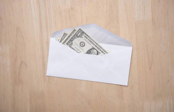 dollar money in the envelope on wood table. bonus, reward,