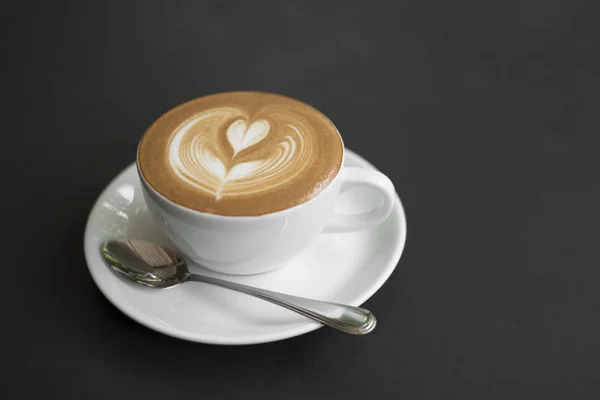 Nahaufnahme Kaffee Latte Art Tasse auf schwarzem Tisch — Stockfoto