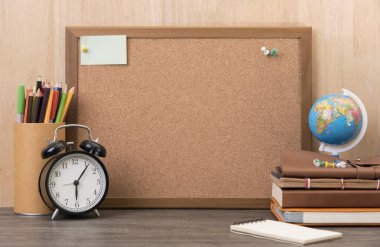 boş mantar pano ile çalar saat, ahşap masa üzerinde kitap.