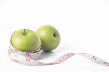 beyaz zemin üzerinde ölçüm bandı ile yeşil elma. 