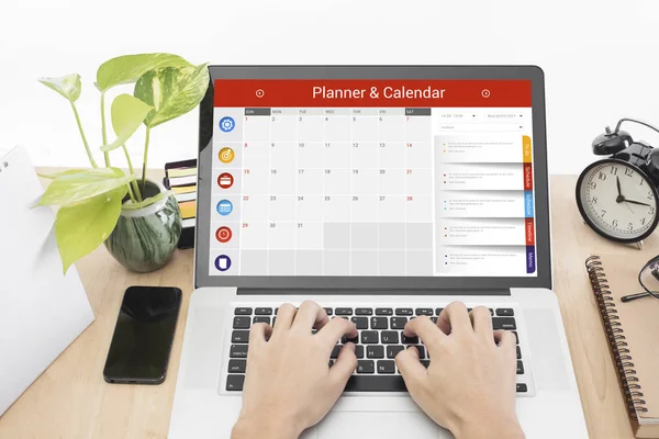 Företag hand att skriva på en laptop tangentbord med kalender Planner — Stockfoto