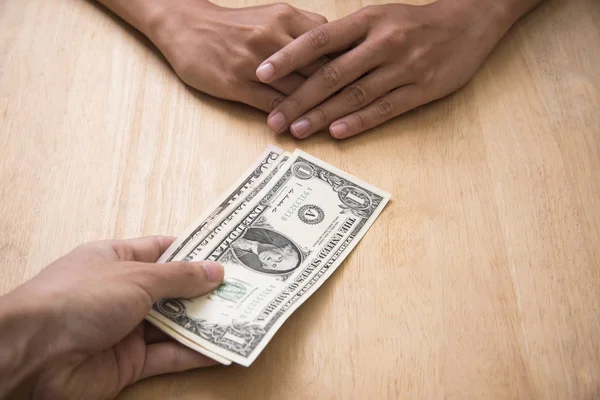 Businessman give money from a bribe on wooden table in office. — Stock Photo, Image