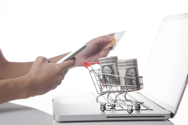 Carrito de compras con dinero en dólares en la computadora. concepto de compras — Foto de Stock