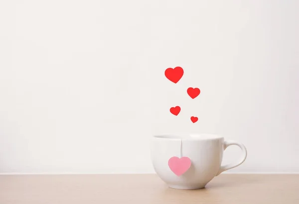 Tasse de thé blanc avec coeur rouge sur table en bois. fond vintage — Photo