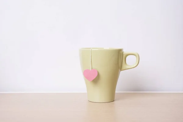 Чашка чаю з червоним серцем на дерев'яному столі. вінтажний фон . — стокове фото