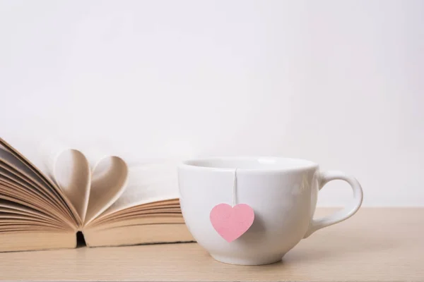 Tea cup with red heart on book shelf. Valentines day vintage Stock Image