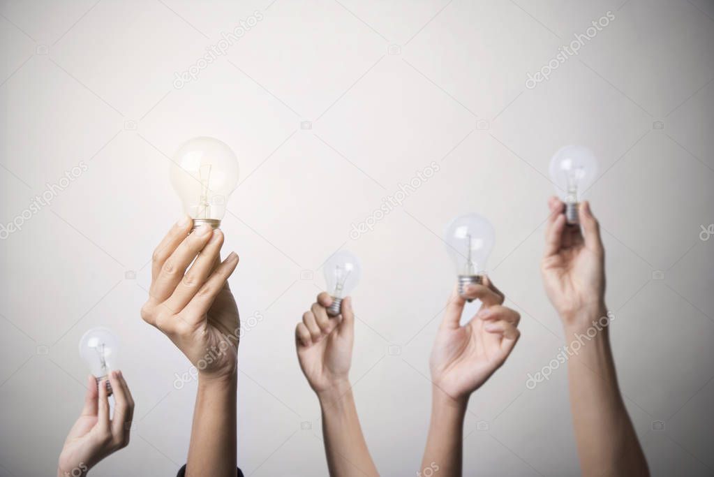 hand holding light bulb, concept teamwork ideas with innovation 