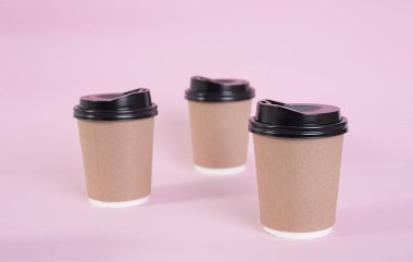 kahverengi kahve kağıt bardak pembe bir arka plan üzerinde. marka için alay.