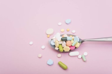 kaşık renkli tıpta. Pembe arka plan eczane. 