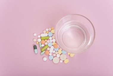 renkli tıp ve pembe bir arka plan üzerinde su.