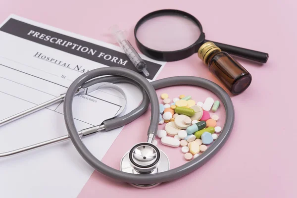 Estetoscopio y medicina colorida. Farmacia sobre fondo rosa . — Foto de Stock