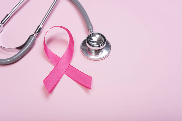 pink ribbon breast cancer and stethoscope on pink background. with copy space