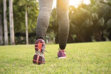 Genç atlet kadınlar Road günbatımı arka plan ile koşu.