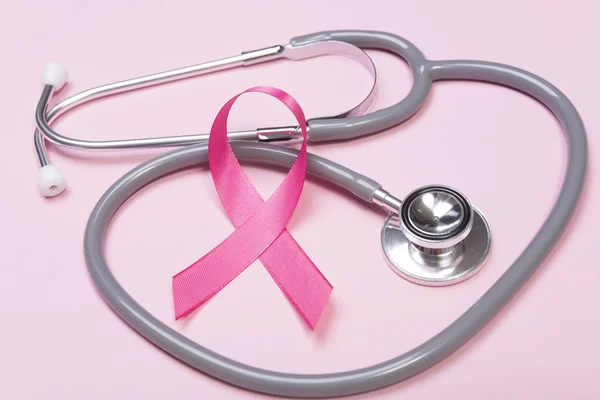 Cancro al seno a nastro rosa e stetoscopio su sfondo rosa . — Foto Stock