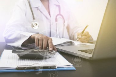 Ofis Masası ve hesap makinesi bilgisayar ile çalışan doktor.
