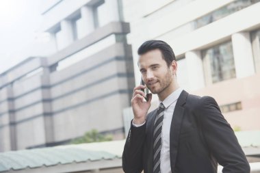 Cep telefonuyla konuşan yakışıklı iş adamı..