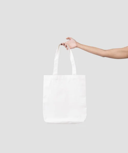 Mão segurando tecido de lona saco para modelo em branco mockup isolado — Fotografia de Stock