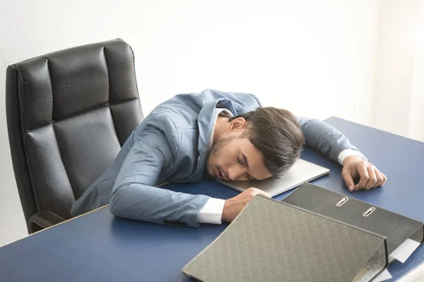 Επιχειρηματίας κουρασμένος, καταπονημένος στον ύπνο πάνω από ένα φορητό υπολογιστή στο γραφείο — Φωτογραφία Αρχείου