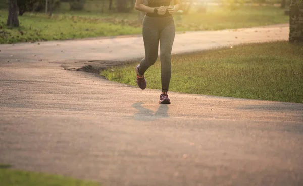 Giovani donne corridore che fanno jogging su strada con sfondo tramonto. Healt — Foto Stock