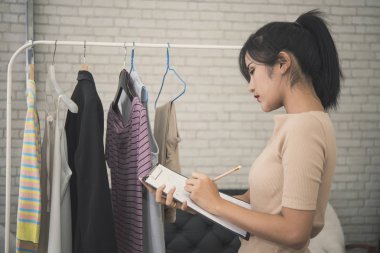 Genç kadın tasarımcı moda terzi giysi için çalışma.