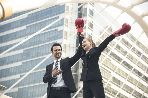 Счастливая предпринимательница в боксёрских перчатках на руках поднятая в победу — стоковое фото
