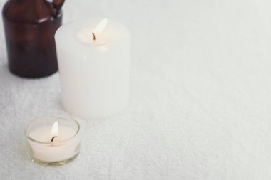 Spa aksesuarları natürmort kokulu mum, çiçek, havlu ile. 