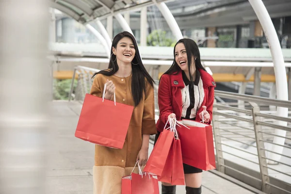 Flickor som håller kassar promenader på köpcentrum — Stockfoto