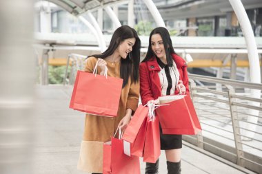 Güzel kızlar alışveriş torbaları alışveriş merkezinde yürüyen holding
