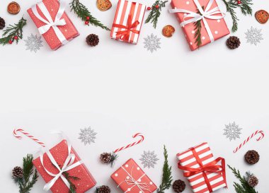 Noel kompozisyonu arka planında süslemeler ve beyaz arka planda hediye kutusu var. Kış, yeni yıl konsepti. Düz konum, üst görünüm, kopyalama alanı.