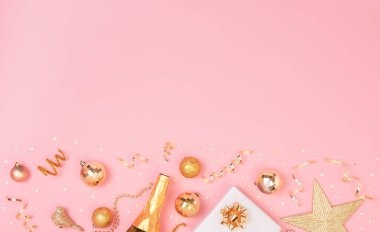 Süslemeli Noel kompozisyonu ve pembe pastel arka planda yıldız konfetisi olan hediye kutusu. Kış, yeni yıl konsepti. Düz konum, üst görünüm, kopyalama alanı.