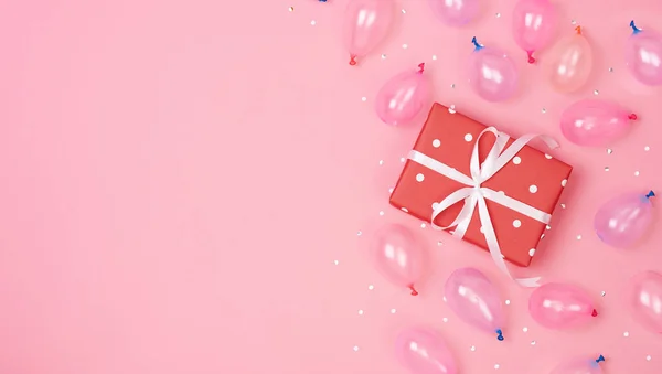 선물 상자는 장식 과 풍선으로 구성되어 있고, 분홍색 파스텔 배경에 조각되어 있다. 생일, 새해 개념. 평면 배치, 상단 뷰, 복사 공간. — 스톡 사진